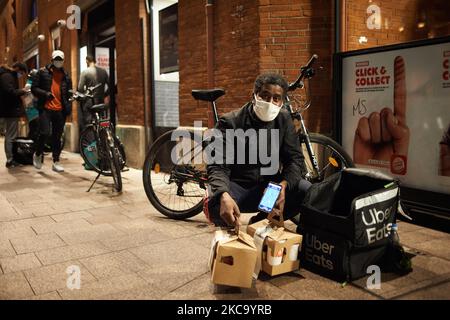 Ein Uber Eats Fahrer zeigt, was er zu liefern hat. Die Nahrungsmittelindustrie hat im vergangenen Jahr einen Aufschwung hinnehmen müssen, da die Pandemie die Menschen gezwungen hat, zu Hause zu bleiben und online einzukaufen, wie in Frankreich, wo diese Branche als „unverzichtbare Dienstleistungen“ gilt. Doch gestern befaßten die Staatsanwälte in Mailand die Lebensmittellieferungsgruppen, Fahrer einzustellen und Geldstrafen in Höhe von 733 Millionen Euro zu zahlen, nachdem eine Untersuchung gezeigt hatte, dass ihre Arbeitsbedingungen unzureichend waren. Die Europäische Kommission hat mit der Einleitung einer öffentlichen Konsultation einen Schritt zur Verbesserung der Rechte der Arbeitnehmer in der Gig-Economy-Wirtschaft unternommen, um ihren legalen Beschäftigungsstatus und wie zu bestimmen Stockfoto