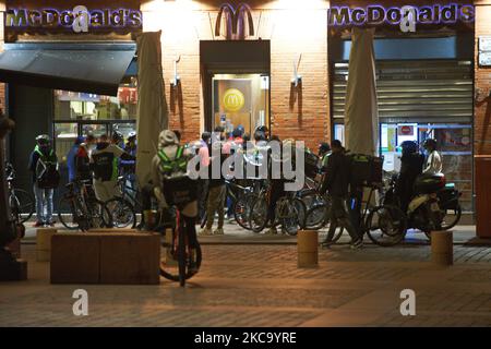 Zustellkräfte warten während der Ausgangssperre Covid-19 vor einem McDonalds-Restaurant auf ihre Bestellungen. Die Nahrungsmittelindustrie hat im vergangenen Jahr einen Aufschwung hinnehmen müssen, da die Pandemie die Menschen gezwungen hat, zu Hause zu bleiben und online einzukaufen, wie in Frankreich, wo diese Branche als „unverzichtbare Dienstleistungen“ gilt. Doch gestern befaßten die Staatsanwälte in Mailand die Lebensmittellieferungsgruppen, Fahrer einzustellen und Geldstrafen in Höhe von 733 Millionen Euro zu zahlen, nachdem eine Untersuchung gezeigt hatte, dass ihre Arbeitsbedingungen unzureichend waren. Die Europäische Kommission hat mit der Einleitung einer öffentlichen Konsultation einen Schritt zur Verbesserung der Rechte der Arbeitnehmer in der Gig-Wirtschaft unternommen Stockfoto