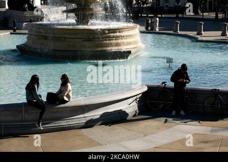 Am 26. Februar 2021 sitzen Menschen in London, England, bei mildem Frühlingswetter an den Springbrunnen des Trafalgar Square. (Foto von David Cliff/NurPhoto) Stockfoto