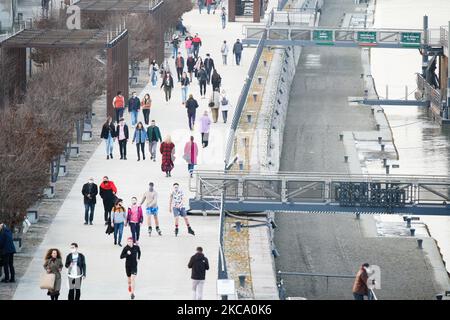 Am 25. Februar 2021 werden Menschen auf dem Boulevard der Weichsel in Warschau, Polen, spazieren gesehen. Die Regierung kündigte am Donnerstag eine Änderung der Regeln an, die die Verwendung jeglicher Art von Gesichtsbedeckung, die keine richtige Gesichtsmaske ist, verbieten wird. Während die Temperaturen weit über 10 Grad Celsius erreichten, versammeln sich viele im Freien ohne Masken entlang der Flussufer. (Foto von Jaap Arriens/NurPhoto) Stockfoto