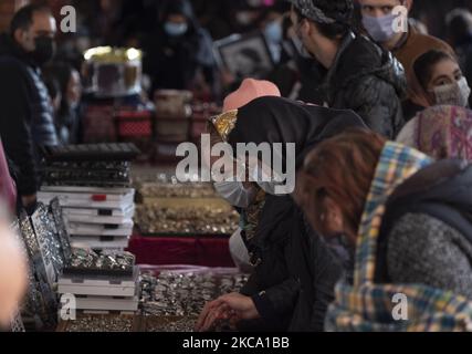 Iranische Frauen, die Schutzmasken tragen, schauen sich Schmuck an, während sie im Parvaneh Friday-Bazaar (Markt) im Zentrum von Teheran einkaufen, während der Ausbruch der neuen Coronavirus-Krankheit (COVID-19) im Iran am 26. Februar 2021 ausbrach. Die iranischen Beamten haben die Menschen gewarnt, dass sich das Land am Rande der vierten Welle des COVID-19-Ausbruchs befindet und es wird passieren, dass die Menschen keine Gesundheitsprotokolle, keine soziale Distanzierung und keine Reisen in die anderen Städte mehr halten. (Foto von Morteza Nikoubazl/NurPhoto) Stockfoto