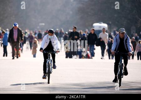 Ein Radfahrer mit Gesichtsmaske fährt am 27. Februar 2021 in den Kensington Gardens in London, England, durch die Frühlingssonne. (Foto von David Cliff/NurPhoto) Stockfoto