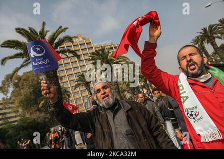 Anhänger rufen Slogans auf, während sie tunesische und Ennahda-Flaggen während einer Demonstration der islamistischen Partei von Ennahda auf der Avenue Mohammed V in der Hauptstadt Tunis, Tunesien, am 27. Februar 2021 schwenken. Zur Unterstützung der „Legitimität“ des parlaments und der Regierung von Premier Hichem Machichi und zum Protest gegen die Ablehnung von Mechichis Umbildung durch Präsident Kais Saied und zum „Schutz der Demokratie“. (Foto von Chedly Ben Ibrahim/NurPhoto) Stockfoto