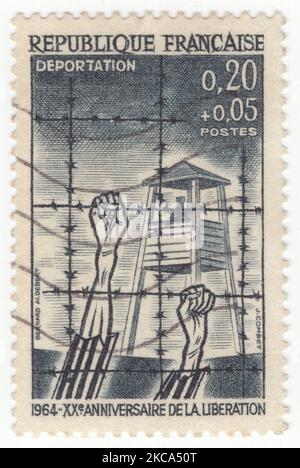 FRANKREICH - 1964. März 21: Eine 20 Rappen plus 5 Rappen schieferschwarze Halbpostmarke mit der Darstellung der „Deportation“, Konzentrationslager mit Wachturm und Stacheldraht. 20.. Jahrestag der Befreiung von den Nazis Stockfoto