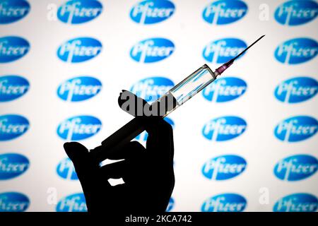 Das Pfizer-Logo ist mit einer Spritze und einer Nadel auf dieser Fototafel am 1. März 2021 in Warschau, Polen, zu sehen. Pfizer geht davon aus, die für die Herstellung einer Charge COVID-19-Impfstoff benötigte Zeit von 110 Tagen auf durchschnittlich 60 Tage nahezu zu halbieren, da der Prozess dadurch effizienter wird und die Produktion ausgebaut wird, teilte das Unternehmen heute den USA mit. (Foto von Jaap Arriens/NurPhoto) Stockfoto