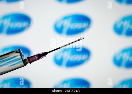 Das Pfizer-Logo ist mit einer Spritze und einer Nadel auf dieser Fototafel am 1. März 2021 in Warschau, Polen, zu sehen. Pfizer geht davon aus, die für die Herstellung einer Charge COVID-19-Impfstoff benötigte Zeit von 110 Tagen auf durchschnittlich 60 Tage nahezu zu halbieren, da der Prozess dadurch effizienter wird und die Produktion ausgebaut wird, teilte das Unternehmen heute den USA mit. (Foto von Jaap Arriens/NurPhoto) Stockfoto