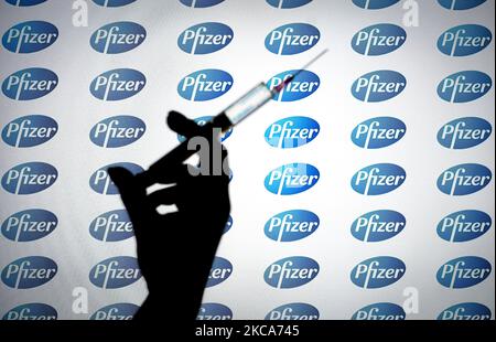 Das Pfizer-Logo ist mit einer Spritze und einer Nadel auf dieser Fototafel am 1. März 2021 in Warschau, Polen, zu sehen. Pfizer geht davon aus, die für die Herstellung einer Charge COVID-19-Impfstoff benötigte Zeit von 110 Tagen auf durchschnittlich 60 Tage nahezu zu halbieren, da der Prozess dadurch effizienter wird und die Produktion ausgebaut wird, teilte das Unternehmen heute den USA mit. (Foto von Jaap Arriens/NurPhoto) Stockfoto
