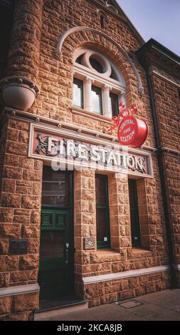 Eine vertikale Aufnahme eines Eingangs zum Steingebäude der Feuerwehr Stockfoto