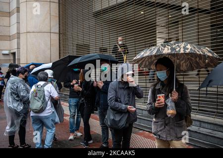 Während einer Anhörung von 47 Oppositionellen, die angeklagt sind, das nationale Sicherheitsgesetz der Stadt in Hongkong, China, am Mittwoch, den 4. März 2021 verletzt zu haben, halten Menschen Regenschirme hoch, während sie vor den Richtern von West-Kowloon warten. Dutzende von pro-demokratischen Aktivisten warten immer noch darauf, herauszufinden, ob sie aus dem Gefängnis befreit werden, bevor sie wegen Subversion-Anschuldigungen vor Gericht gestellt werden, während Peking die Pläne zur Überarbeitung des Wahlsystems der Finanzzentren vortreibt. (Foto von Vernon Yuen/NurPhoto) Stockfoto