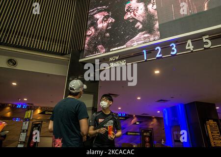 Menschen tragen Schutzmasken und warten darauf, dass ihr Film am 5. März 2021 in einem Kino in Kuala Lumpur beginnt. Die Kinos wurden nach der Schließung des COVID-19-Coronavirus mit Richtlinien zur sozialen Distanzierung wieder eröffnet. (Foto von Mohd Firdaus/NurPhoto) Stockfoto