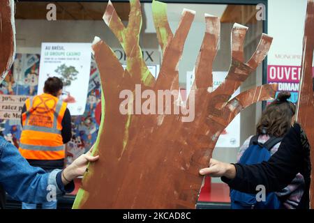 XR-Mitglieder halten einen falschen toten Baum, um die Abholzung zu symbolisieren. XR Toulouse filterte den Eingang eines Monoprix-Geschäfts, da XR eine Klage gegen die Casino-Gruppe unterstützt (Casino, Monoprix, Naturalia, Franprix usw.). Diese Klage gegen die Casino-Gruppe wurde von einem Kollektiv von NGOs und Verbänden (Opiac, Canopee, envol vert, sherpa, notre affaire a tous..) eingeleitet, weil sie die Verantwortung der Casino-Gruppe beim Schneiden des Amazonas-Regenwaldes anführen. Allein im Jahr 2019 gilt die Casino-Gruppe als verantwortlich für den klaren Schnitt von 56,000ha Amazonas-Regenwald. Toulouse. März 6. 2021. (Foto von Stockfoto