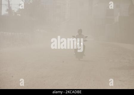 Am 06. März 2021 fährt ein Mann mit dem Fahrrad durch eine staubige, verkehrsreiche Straße in Dhaka, Bangladesch. (Foto von Kazi Salahuddin Razu/NurPhoto) Stockfoto