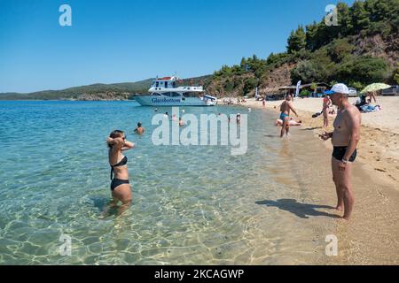 Die Strand von Aretes in Toroni in Chalkidiki. Der Strand mit dem goldenen Sand und dem kristallklaren smaragdgrünen Wasser, typisch für die Ägäis und das Mittelmeer, besteht aus 3 verschiedenen Buchten. Die Küste, die von felsigen Hügeln umgeben ist, ist ein versteckter Schatz für Einheimische und Touristen ohne die überfüllten Sommerszenen mit den Strandbars. Chalkidiki ist ein beliebtes Urlaubsziel, berühmt für die besten Strände des Landes, die man mit dem Auto erreichen kann, in der Nähe der Stadt Thessaloniki. Griechenland drängt auf einen COVID-Impfpass, damit das Land während des saisonalen Tourismus Touristen aufnehmen kann Stockfoto