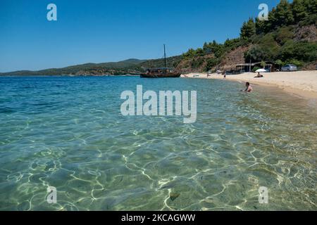 Die Strand von Aretes in Toroni in Chalkidiki. Der Strand mit dem goldenen Sand und dem kristallklaren smaragdgrünen Wasser, typisch für die Ägäis und das Mittelmeer, besteht aus 3 verschiedenen Buchten. Die Küste, die von felsigen Hügeln umgeben ist, ist ein versteckter Schatz für Einheimische und Touristen ohne die überfüllten Sommerszenen mit den Strandbars. Chalkidiki ist ein beliebtes Urlaubsziel, berühmt für die besten Strände des Landes, die man mit dem Auto erreichen kann, in der Nähe der Stadt Thessaloniki. Griechenland drängt auf einen COVID-Impfpass, damit das Land während des saisonalen Tourismus Touristen aufnehmen kann Stockfoto