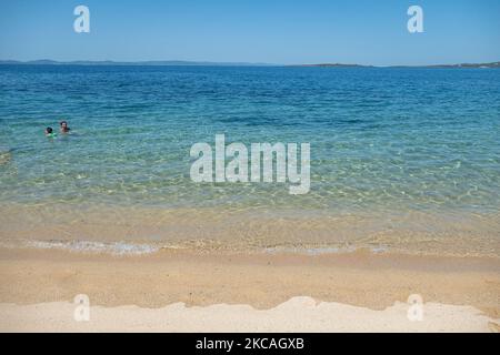 Die Strand von Aretes in Toroni in Chalkidiki. Der Strand mit dem goldenen Sand und dem kristallklaren smaragdgrünen Wasser, typisch für die Ägäis und das Mittelmeer, besteht aus 3 verschiedenen Buchten. Die Küste, die von felsigen Hügeln umgeben ist, ist ein versteckter Schatz für Einheimische und Touristen ohne die überfüllten Sommerszenen mit den Strandbars. Chalkidiki ist ein beliebtes Urlaubsziel, berühmt für die besten Strände des Landes, die man mit dem Auto erreichen kann, in der Nähe der Stadt Thessaloniki. Griechenland drängt auf einen COVID-Impfpass, damit das Land während des saisonalen Tourismus Touristen aufnehmen kann Stockfoto