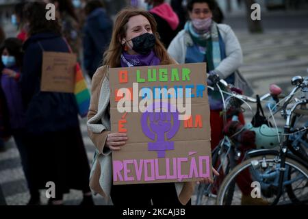 Eine Frau, die eine schützende Gesichtsmaske trägt und ein Signal hält, das den Platz der Frauen in der Revolution ausgibt, nimmt an einer Kundgebung anlässlich des Internationalen Frauentags in Lissabon, Portugal, am 8. März 2021 Teil. (Foto von Pedro FiÃºza/NurPhoto) Stockfoto