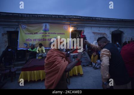 Ein Hindu-Sadhu oder Heiliger, der in einer Tradition tanzt, spielt am Mittwoch, den 10. März 2021, am Vorabend von Maha Shivaratri in den Räumlichkeiten des Pashupatinath-Tempels, Kathmandu, Nepal, Melodien. Weniger Hindu-Sadhu oder Heiliger aus Indien und Nepal kommen in Pashupatinath an, um das Festival wegen Covid-19 zu feiern. (Foto von Narayan Maharjan/NurPhoto) Stockfoto