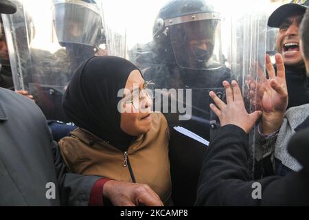 Während einer Demonstration vor dem Hauptquartier der tunesischen Zweigstelle der Internationalen Union für muslimische Gelehrte (IUMS) in der tunesischen Hauptstadt Tunis am 10. März 2021 zischt eine Protesterin islamistischer Bewegungen mit Sicherheitskräften, die Schilde halten, Aus Protest gegen den Präsidenten der Freien Destourien Partei (PDL), Abir Moussi und ihre Anhänger, die vor dem Hauptquartier der IUL ein Sit-in abhalten, um ihre Auflösung zu fordern. (Foto von Chedly Ben Ibrahim/NurPhoto) Stockfoto