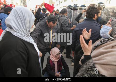 Eine Protesterin islamistischer Bewegungen schreit Parolen, während sie vor Sicherheitskräften auf dem Boden sitzt, während einer Demonstration vor dem Hauptquartier der tunesischen Niederlassung der Internationalen Union für muslimische Gelehrte (IUMS) in der Hauptstadt Tunis, Tunesien, am 10. März 2021, Aus Protest gegen den Präsidenten der Freien Destourien Partei (PDL), Abir Moussi und ihre Anhänger, die vor dem Hauptquartier der IUL ein Sit-in abhalten, um ihre Auflösung zu fordern. (Foto von Chedly Ben Ibrahim/NurPhoto) Stockfoto