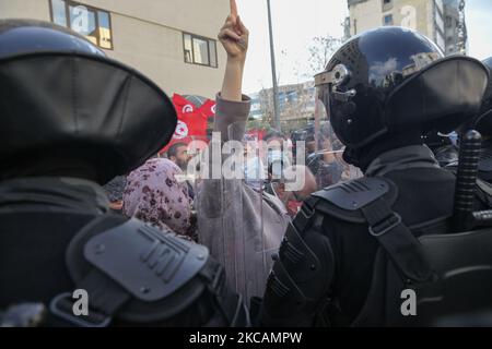 Eine Protesterin islamistischer Bewegungen hebt ihren Finger vor den Sicherheitskräften während einer Demonstration vor dem Hauptquartier der tunesischen Zweigstelle der Internationalen Union für muslimische Gelehrte (IUMS) in der Hauptstadt Tunis, Tunesien, am 10. März 2021, Aus Protest gegen den Präsidenten der Freien Destourien Partei (PDL), Abir Moussi und ihre Anhänger, die vor dem Hauptquartier der IUL ein Sit-in abhalten, um ihre Auflösung zu fordern. (Foto von Chedly Ben Ibrahim/NurPhoto) Stockfoto