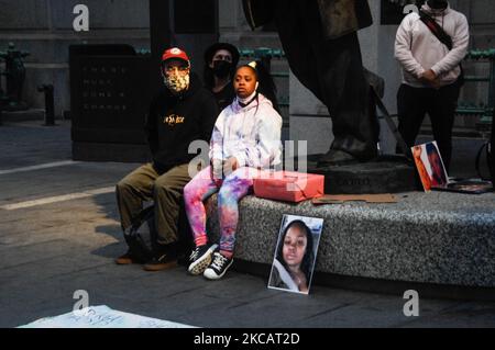 Ein Vater und eine Tochter sitzen neben einem Bild von Breana Taylor zu Füßen der Octavious-Statue, während sie den Geschichten von schwarzen Frauen lauschen, die das Leben ihrer Umgebung während einer Versammlung der Hüter meiner Schwestern im Rathaus von Philadelphia berührt haben, PA am 12. März 2021. (Foto von Cory Clark/NurPhoto) Stockfoto