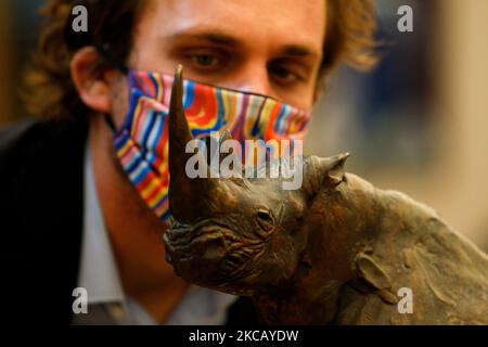 Ein Mitarbeiter posiert mit einer Bronzeskulptur mit dem Titel „Rhino“ des südafrikanischen Künstlers Dylan Lewis, die auf GBP7.000 bis 10.000 geschätzt wird, während einer Pressevorschau für den bevorstehenden Verkauf moderner und zeitgenössischer afrikanischer Kunst im Bonhams Auktionshaus in London, England, am 15. März 2021. Der Verkauf findet am Mittwoch, den 17. März statt. (Foto von David Cliff/NurPhoto) Stockfoto