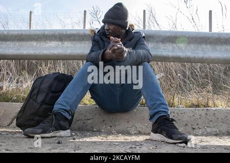 Auf der Autobahn in der Nähe der Stadt Orestiada in der Region Evros, Thrakien, in Griechenland, befinden sich Polizeiautos und Polizeibeamte, die 2 Migranten ohne Papiere halten, einen aus Afghanistan und einen aus Afrika, die illegal die Grenzen der Türkei überquerten. Der Evros-Fluss oder Martisa oder Meric ist die südöstlichere Außengrenze der EU und des Schengen-Raums. Asylbewerber werden entlang der griechisch-türkischen Grenzen gefangen genommen, während sie versuchen, nach Griechenland und in die Europäische Union einzureisen. Die hellenische Polizei und Frontex-Truppen machen die Grenzpatrouille und nehmen täglich fest oder verhaften Migranten, Flüchtlinge und Schmuggler auf den griechischen Stockfoto