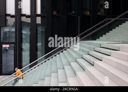 Ein Mann mit seiner Maske sitzt auf der Treppe in der Nähe der Medienhafenbrücke in Düsseldorf, 18. März 2021. (Foto von Sergii Chartschenko/NurPhoto) Stockfoto