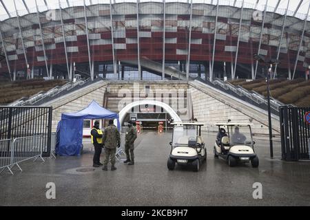 Am 21. März 2021 werden in Warschau, Polen, Militärangehörige gesehen, die einen Eingang zum Nationalstadion bewachen, wo derzeit Menschen gegen COVID-19 geimpft werden. Polen wird ab montag im Rahmen der ersten Phase des Impflaufs COVID-19 mit der Impfung von 60- bis 69-Jährigen beginnen. Die Impfregistrierung begann am 15. Januar, wobei diejenigen ab 70 Jahren zuerst behandelt wurden. Polen liegt derzeit im EU-Durchschnitt bei rund 13 pro 100 der Bevölkerung, die erste Impfungen erhalten. (Foto von Jaap Arriens/NurPhoto) Stockfoto