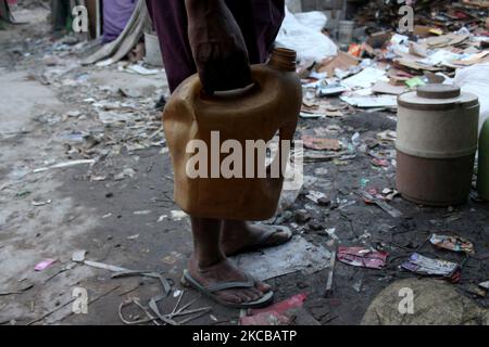 Am Weltwassertag in Neu-Delhi, Indien, kommt am 22. März 2021 ein Mann an, um Plastikbehälter mit Wasser aus einer defekten Trinkwasserleitung in einem Slum-Gebiet zu füllen. (Foto von Mayank Makhija/NurPhoto) Stockfoto