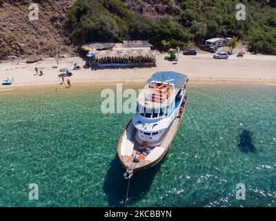 Luftpanorama aus der Vogelperspektive von einer Drohne des Aretes-Strandes, in der Gegend von Toroni, einem versteckten Juwel in Chalkidiki. Der Strand mit goldenem Sand und transparentem, kristallklarem smaragdgrünen Wasser, exotischem und tropischem Stil mit Pinien in der Nähe des Sandes, typisch für die Ägäis und das Mittelmeer, besteht aus 3 verschiedenen Buchten, wie sie von einigen Touristen gesehen wurden, die mit einem kleinen Schiff ankamen. Die Küste, die von felsigen Hügeln umgeben ist, ist ein versteckter Schatz für Einheimische und Touristen ohne die überfüllten Sommerszenen mit den Strandbars. Chalkidiki ist ein beliebtes Urlaubsziel, berühmt für die besten Strände in Stockfoto