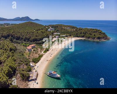 Luftpanorama aus der Vogelperspektive von einer Drohne des Aretes-Strandes, in der Gegend von Toroni, einem versteckten Juwel in Chalkidiki. Der Strand mit goldenem Sand und transparentem, kristallklarem smaragdgrünen Wasser, exotischem und tropischem Stil mit Pinien in der Nähe des Sandes, typisch für die Ägäis und das Mittelmeer, besteht aus 3 verschiedenen Buchten, wie sie von einigen Touristen gesehen wurden, die mit einem kleinen Schiff ankamen. Die Küste, die von felsigen Hügeln umgeben ist, ist ein versteckter Schatz für Einheimische und Touristen ohne die überfüllten Sommerszenen mit den Strandbars. Chalkidiki ist ein beliebtes Urlaubsziel, berühmt für die besten Strände in Stockfoto