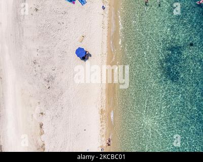 Luftpanorama aus der Vogelperspektive von einer Drohne des Aretes-Strandes, in der Gegend von Toroni, einem versteckten Juwel in Chalkidiki. Der Strand mit goldenem Sand und transparentem, kristallklarem smaragdgrünen Wasser, exotischem und tropischem Stil mit Pinien in der Nähe des Sandes, typisch für die Ägäis und das Mittelmeer, besteht aus 3 verschiedenen Buchten, wie sie von einigen Touristen gesehen wurden, die mit einem kleinen Schiff ankamen. Die Küste, die von felsigen Hügeln umgeben ist, ist ein versteckter Schatz für Einheimische und Touristen ohne die überfüllten Sommerszenen mit den Strandbars. Chalkidiki ist ein beliebtes Urlaubsziel, berühmt für die besten Strände in Stockfoto