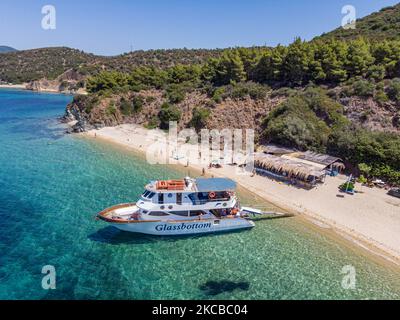 Luftpanorama aus der Vogelperspektive von einer Drohne des Aretes-Strandes, in der Gegend von Toroni, einem versteckten Juwel in Chalkidiki. Der Strand mit goldenem Sand und transparentem, kristallklarem smaragdgrünen Wasser, exotischem und tropischem Stil mit Pinien in der Nähe des Sandes, typisch für die Ägäis und das Mittelmeer, besteht aus 3 verschiedenen Buchten, wie sie von einigen Touristen gesehen wurden, die mit einem kleinen Schiff ankamen. Die Küste, die von felsigen Hügeln umgeben ist, ist ein versteckter Schatz für Einheimische und Touristen ohne die überfüllten Sommerszenen mit den Strandbars. Chalkidiki ist ein beliebtes Urlaubsziel, berühmt für die besten Strände in Stockfoto