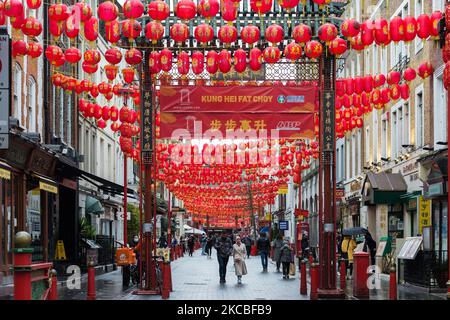 LONDON, VEREINIGTES KÖNIGREICH - 25. MÄRZ 2021: Am 25. März 2021 in London, England, laufen Menschen in Chinatown, die mit roten Laternen geschmückt sind, während England noch unter der dritten Sperre steht, um die Covid-19-Infektionsraten zu senken. Die Regierung hat einen Plan für die Entsperrung des Landes in vier Phasen im Laufe des Impfprogramms aufgestellt, mit einer weiteren Lockerung der Beschränkungen ab dem 29. März, einschließlich der Aufhebung der Aufenthaltsordnung zu Hause, der sechs Personen die Möglichkeit gibt, sich draußen zu treffen und Sporteinrichtungen im Freien zu eröffnen. (Foto von Wiktor Szymanowicz/NurPhoto) Stockfoto