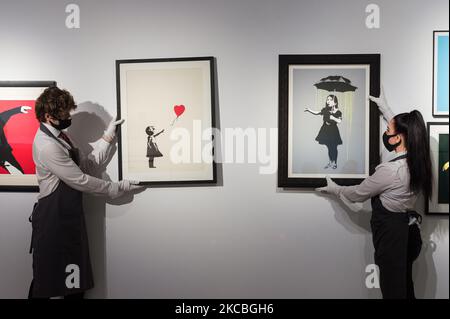 LONDON, GROSSBRITANNIEN - 26. MÄRZ 2021: Mitarbeiter präsentieren Banksy's (geb.1974) Siebdrucke (L-R) Girl with Balloon, 2004, Schätzung: £300.000-500.000 und NOLA (Yellow Rain), 2008, Schätzung: £200.000-300.000 während der Vorbereitungen für „Banksy: Ich kann nicht glauben, dass ihr Morde diesen Online-Verkauf am 26. März 2021 in Christie's Auktionshaus in London, England, tatsächlich kauft. (Foto von Wiktor Szymanowicz/NurPhoto) Stockfoto