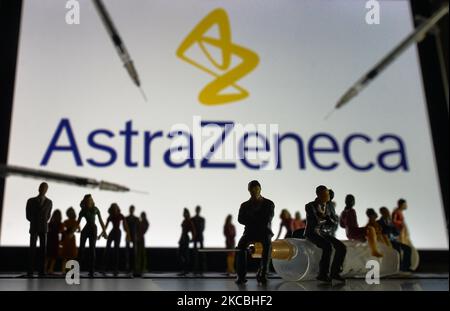 Medizinische Spritzen und kleine Figuren von Menschen sind vor dem AstraZeneca-Logo auf einem Bildschirm zu sehen. Am Samstag, den 26. März 2021, in Dublin, Irland. (Foto von Artur Widak/NurPhoto) Stockfoto