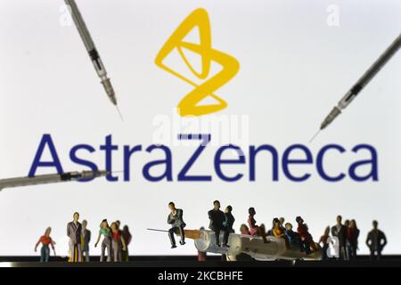 Medizinische Spritzen und kleine Figuren von Menschen sind vor dem AstraZeneca-Logo auf einem Bildschirm zu sehen. Am Samstag, den 26. März 2021, in Dublin, Irland. (Foto von Artur Widak/NurPhoto) Stockfoto