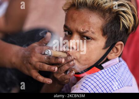 Ein Teenager Boy raucht am 28. März 2021 auf der Treppe des Jama Masjid in Alt-Delhi, Indien, einen Zigarren. Einer von sechs Studenten im Alter zwischen acht und 11 Jahren in Ost Delhiâ €™s städtischen Schulen sind süchtig nach Substanzen von Alkohol und Tabak zu industriellen Klebstoff und injizierbare Drogen, eine Umfrage durchgeführt von der East Delhi Municipal Corporation (EDMC) hat festgestellt, Ein Hinweis darauf, wie schamlos die Gesetze von Haushändlern verletzt werden, die versuchen, junge Kinder zu Hardcore-Süchtigen zu machen. (Foto von Nasir Kachroo/NurPhoto) Stockfoto
