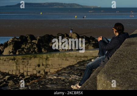 Eine junge Frau genießt einen Blick von Seapoint, Dublin, während der COVID-19-Sperre der Stufe 5. Am Montag, den 29. März 2021, in Dublin, Irland. (Foto von Artur Widak/NurPhoto) Stockfoto