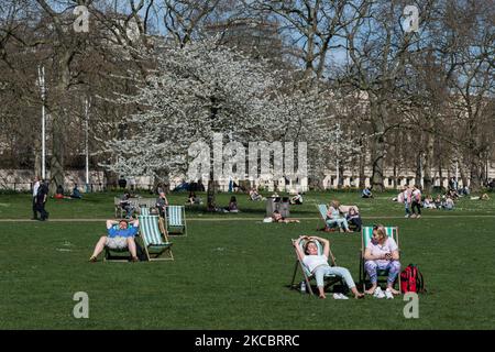 LONDON, VEREINIGTES KÖNIGREICH - 30. MÄRZ 2021: Während des außergewöhnlich warmen und sonnigen Wetters im St James's Park sitzen Menschen auf Liegestühlen und nutzen die gelockerten Coronavirus-Einschränkungen am 30. März 2021 in London, England. Die Temperaturen in London werden voraussichtlich über zwei Tage 24C erreichen, die durch eine Mini-Hitzewelle vom Kontinent verursacht werden. (Foto von Wiktor Szymanowicz/NurPhoto) Stockfoto