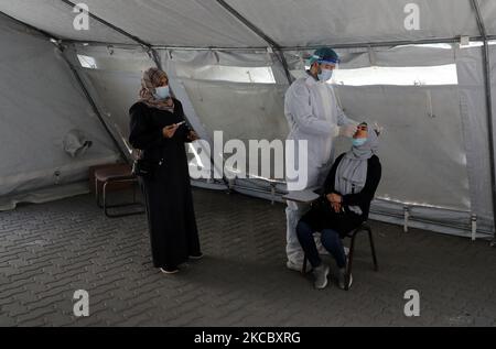 Ein palästinensisches Gesundheitshelfer nimmt am 1. April 2021 in einer UNRWA-Klinik in Gaza-Stadt, Palästina, eine Nasenabstrichprobe einer Frau, um COVID-19 zu testen. (Foto von Majdi Fathi/NurPhoto) Stockfoto