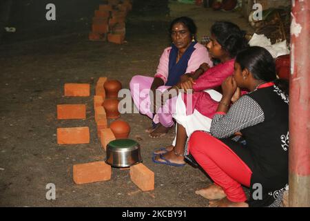 Hindu-Frauen sitzen am Straßenrand über Nacht, um am 19. Februar 2019 in der Nacht des 9.. Tages des 10-tägigen Attukal Pongala Mahotsavam Festivals in der Stadt Thiruvananthapuram (Trivandrum), Kerala, Indien, einen Platz für den nächsten Morgen zu sichern, um Pongala in der Nähe des Attukal Bhagavathy Tempels zu kochen. Das Attukal Pongala Mahotsavam Festival wird jedes Jahr von Millionen Hindu-Frauen gefeiert. Während dieses Festivals bereiten Frauen Pongala (Reis gekocht mit Jaggery, Ghee, Kokosnuss sowie andere Zutaten) im Freien in kleinen Töpfen zu gefallen die Göttin Attukal Devi (im Volksmund bekannt als Attukal Amma Stockfoto