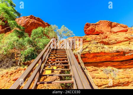 Holztreppe entlang des Kings Canyon Rim mit Fußgängerbrücke über den Garden of Eden im Watarrka National Park, Australien. Stufen führen zum Gipfel des Canyons mit Stockfoto