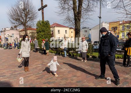 Die Gläubigen kommen am 3. April 2021 in Ostrowiec Swietokrzyski, Polen, in die Kirche, um ihr Osteressen mit einem heiligen Wasser zu segnen. In der polnischen Tradition kommen Familien mit Körben voller Osterkost in die Kirche, um ihre Nahrung von einem Priester mit Weihwasser gesegnet zu bekommen in diesem Jahr findet der Segen im Freien vor der Kirche statt, um das Risiko einer Coronavirus-Infektion zu begrenzen. Ostern ist ein wichtiger religiöser Feiertag in Polen, einem katholischen europäischen Land. (Foto von Dominika Zarzycka/NurPhoto) Stockfoto