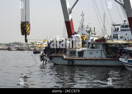 Ein Mitglied des Rettungsteams springt von einem Boot, um unter Wasser zu gehen, während es am 5. April 2021 versucht, ein gekenpftes Boot im Fluss Shitalakshya in Narayanganj wiederzuerlangen. (Foto von Ziaul Haque/NurPhoto) Stockfoto