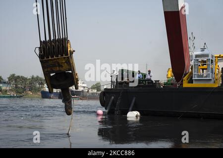 Ein Mann, der das Rettungsteam vom Rettungsschiff aus leitet, als er am 5. April 2021 versuchte, ein kentergroßes Boot im Fluss Shitalakshya in Narayanganj wiederzuerlangen. (Foto von Ziaul Haque/NurPhoto) Stockfoto