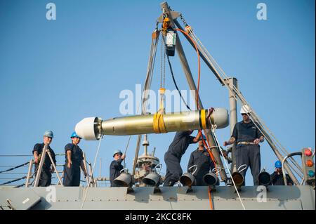 Seeleute transportieren einen MK46 MOD 5A(S) Torpedo an Bord der USS Truxton. Stockfoto