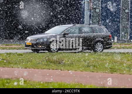 Auto auf der Straße während des Schnees. Der Schneefall in den Niederlanden macht das erste „Weiße Ostern“ nach langer Zeit mit einem deutlichen Temperaturabfall und erreicht nach Angaben der niederländischen Wetterbehörde KNMI den Gefrierpunkt, was den Ostermontag zu einem der kältesten Tage aller Zeiten mit niedrigen Temperaturen macht. Zusätzlich zu Schnee, Hagel und hoher Geschwindigkeit kam es zu starkem eisgekühlten Wind. Die KNMI hat für Montag Abend eine gelbe Wetterwarnung herausgegeben, die besagt, dass es starke Winde und rutschige Bedingungen auf den Straßen geben wird. Der Blast des kalten Wetters mit dem unheimlichen Wetter erschien nach historischen Tagen von Stockfoto