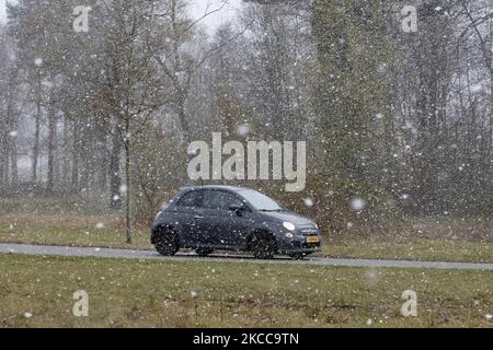 Auto auf der Straße während des Schnees. Der Schneefall in den Niederlanden macht das erste „Weiße Ostern“ nach langer Zeit mit einem deutlichen Temperaturabfall und erreicht nach Angaben der niederländischen Wetterbehörde KNMI den Gefrierpunkt, was den Ostermontag zu einem der kältesten Tage aller Zeiten mit niedrigen Temperaturen macht. Zusätzlich zu Schnee, Hagel und hoher Geschwindigkeit kam es zu starkem eisgekühlten Wind. Die KNMI hat für Montag Abend eine gelbe Wetterwarnung herausgegeben, die besagt, dass es starke Winde und rutschige Bedingungen auf den Straßen geben wird. Der Blast des kalten Wetters mit dem unheimlichen Wetter erschien nach historischen Tagen von Stockfoto